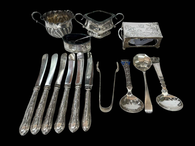 Two silver salts, cream jug, three spoons, match box holder, tongs, and silver handled tea knives.