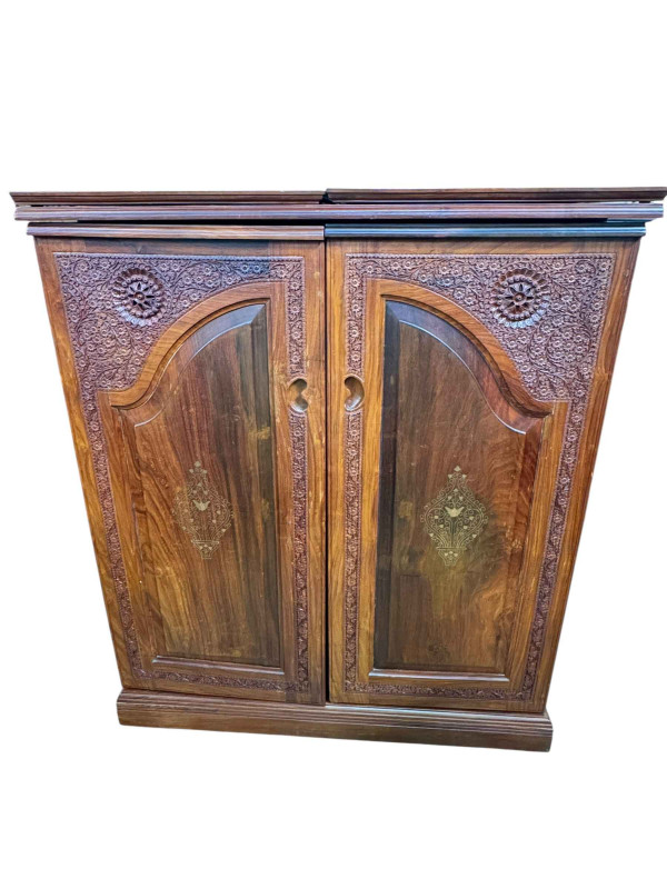 Eastern carved hardwood and brass inlaid cocktail cabinet, the double hinged lid above two doors enclosing a well fitted interior, 117cm by 99cm by 54cm.