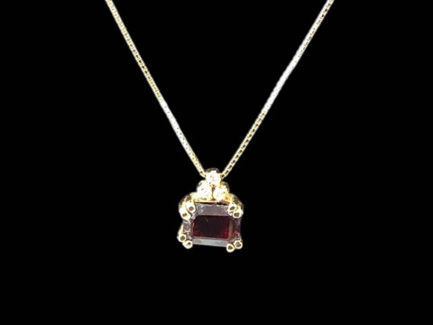 18 carat gold chain with garnet and diamond set pendant.