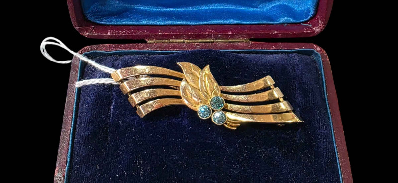 9 carat gold brooch set with blue gem stones (aquamarine?), 6.25cm across.