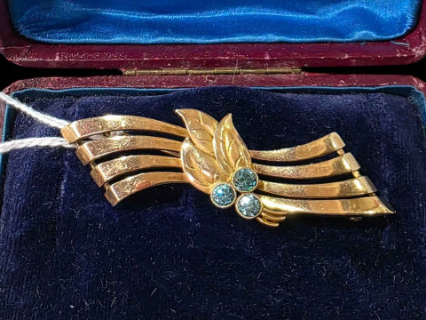 9 carat gold brooch set with blue gem stones (aquamarine?), 6.25cm across.