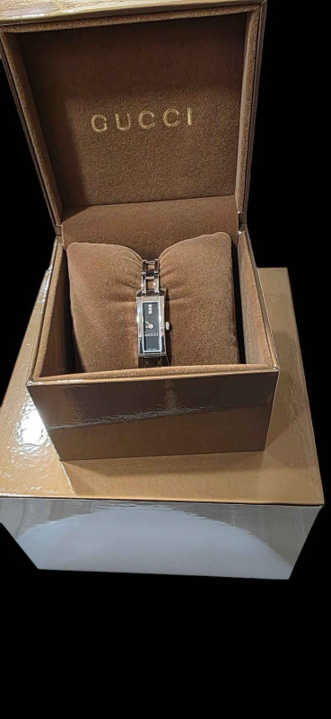 Gucci ladies bracelet watch, with boxes and book.