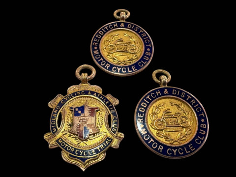 Three 9 carat gold motor cycling medallions with enamel borders.