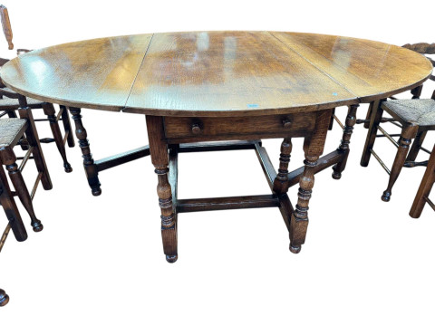 Titchmarsh & Goodwin oak drop leaf dining table having two frieze drawers, 75cm by 183cm by 129.5cm (leaves elevated), together with a set of six rush seated ladder back dining chairs. thumbnail