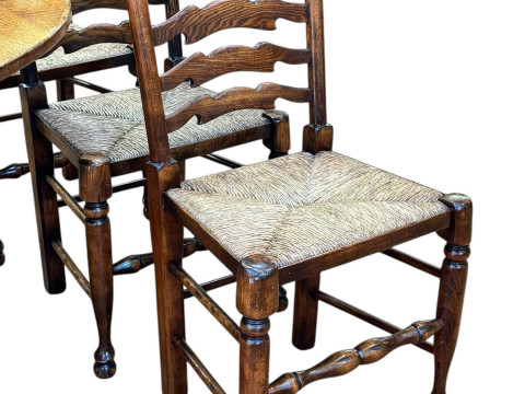 Titchmarsh & Goodwin oak drop leaf dining table having two frieze drawers, 75cm by 183cm by 129.5cm (leaves elevated), together with a set of six rush seated ladder back dining chairs. thumbnail
