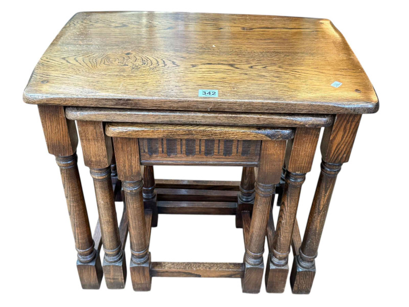 Nest of three oak turned leg tables, largest 55cm by 58.5cm by 38cm.