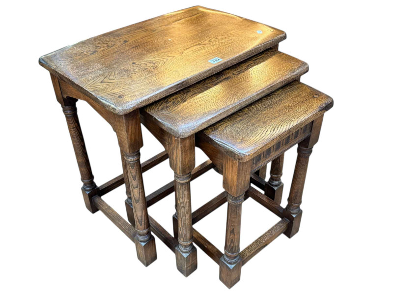 Nest of three oak turned leg tables, largest 55cm by 58.5cm by 38cm.