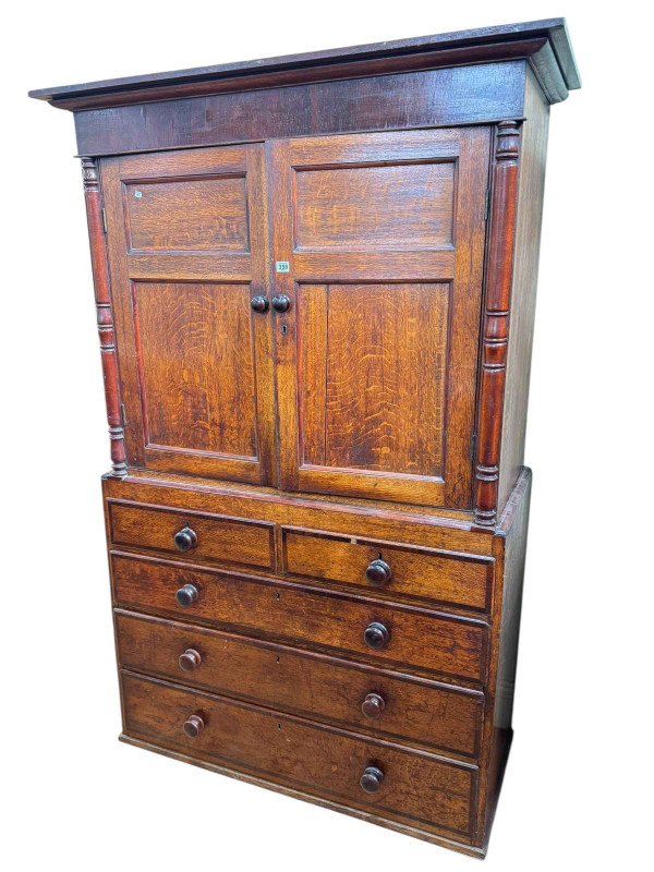 Victorian oak and mahogany linen press having two panelled cupboard doors above two short and three long graduated drawers, 190cm by 123.5cm by 51cm.