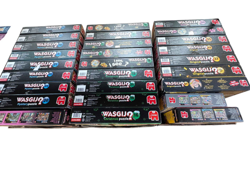 Three boxes of Wasgij puzzles, Original, Mystery and Christmas, and two boxes of Jan Van Haasteren comic jigsaw puzzles.