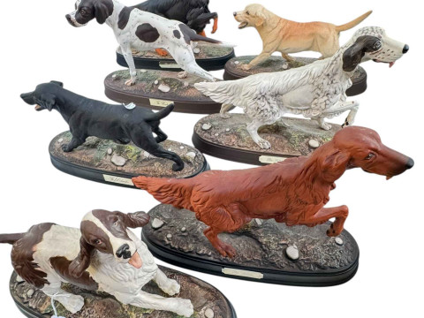 Seven Royal Doulton dogs on plinths, three Setters, two Labradors, Pointer...
