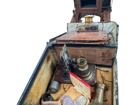 Vintage plate camera, three Churchill coins and three Bermuda crowns.