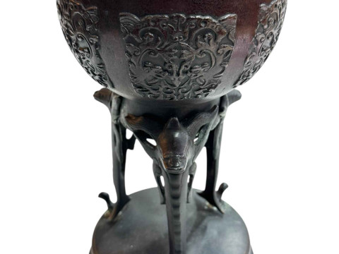 Large Japanese bronze vase with twin handles decorated in relief mythical creature and flower raised on three legs to circular base, 45.5cm. thumbnail