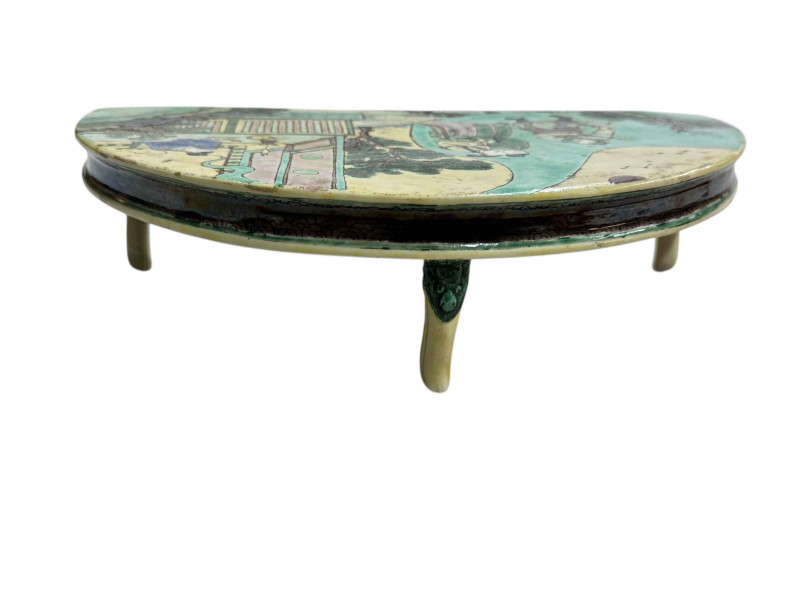Chinese famille verte half-moon stand with figure decoration and on mask headed shaped legs, 27cm across.