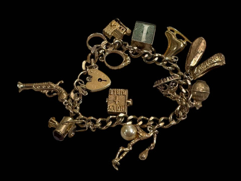 9 carat gold charm bracelet with eleven charms.