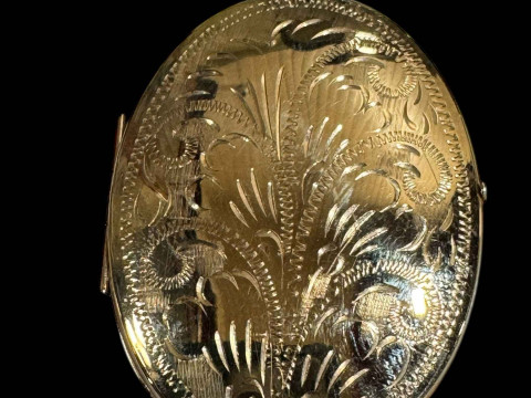 9 carat gold oval locket with engraved decoration.
