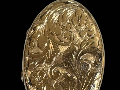 9 carat gold oval locket with engraved decoration.