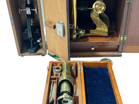 Three boxed vintage microscopes.