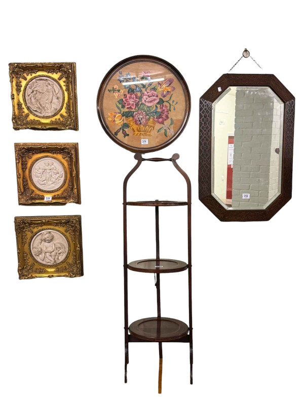Edwardian mahogany and line inlaid three tier folding cakestand, octagonal oak framed bevelled wall mirror, circular floral needlework and set of three gilt framed classical plaques (6).
