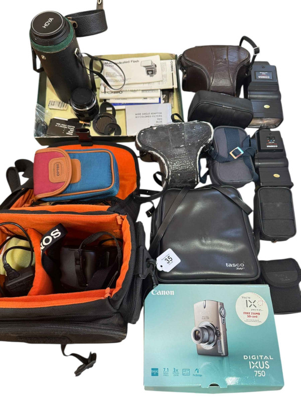 Collection of photographic equipment including camera, lenses, flash guns etc.