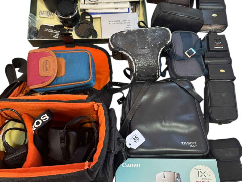 Collection of photographic equipment including camera, lenses, flash guns...