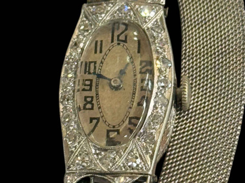 Platinum and diamond set ladies cocktail watch with mesh design bracelet strap, the oval face surrounded by twenty round cut diamonds to hinged diamond set shoulders. thumbnail