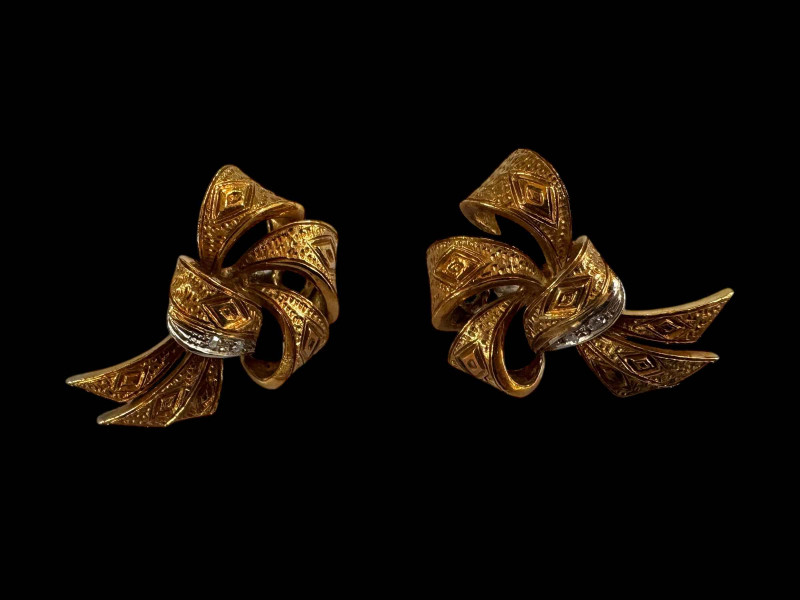 Pair of 18 carat gold ribbon design earrings with small two diamond decorative row and white gold clip fastenings.