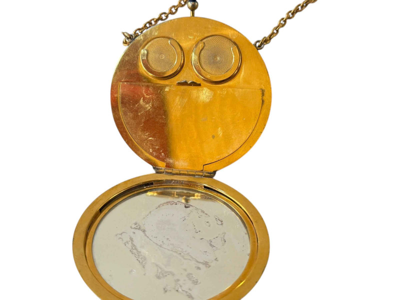 Gilt metal and enamel decorated sovereign case in the form of a ladies compact.