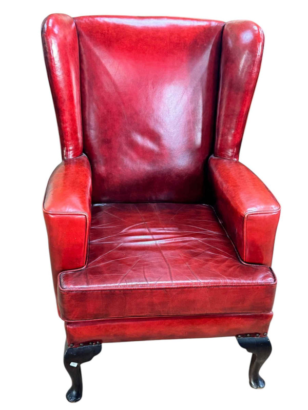 Red leather wing armchair on cabriole legs.
