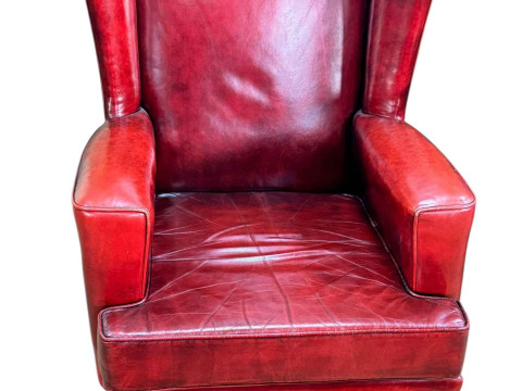 Red leather wing armchair on cabriole legs.