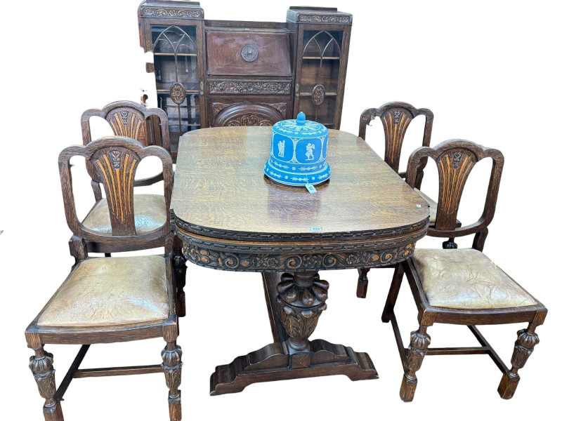 1930's carved oak Lees style six piece dining suite comprising bureau centre cabinet, draw leaf dining table and four chairs.