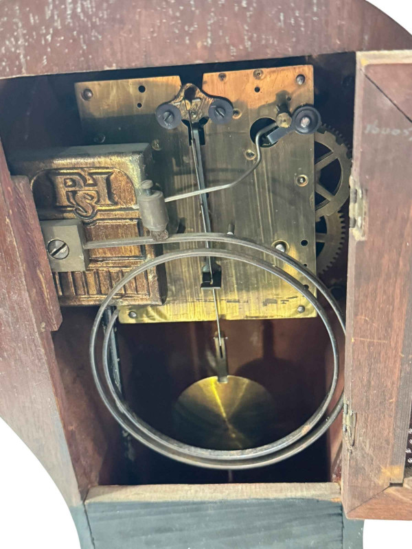 Edwardian inlaid mahogany balloon mantel clock with brass handles and bun feet.