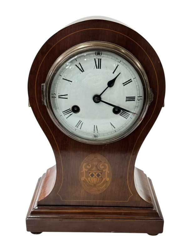 Edwardian inlaid mahogany balloon mantel clock with brass handles and bun feet.