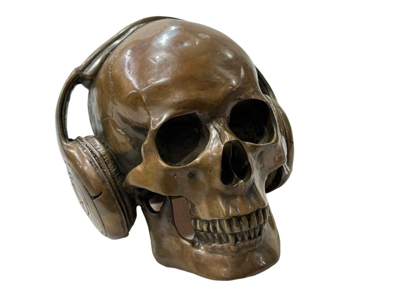 Novelty brass model of a skull wearing headphones.