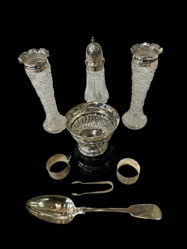 Silver embossed bowl with plinth, pair Victorian silver napkin rings, tablespoon, pair silver mounted vases, tongs, and caster (7).