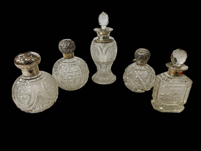 Collection of five silver topped and mounted scent bottles.