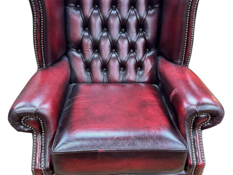 Ox blood buttoned leather and studded wing armchair.
