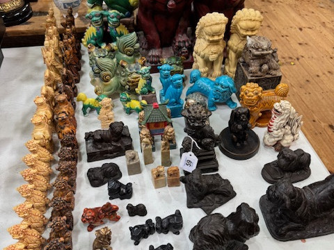 Collection of mostly Chinese Foo Dog ornaments including chess pieces.