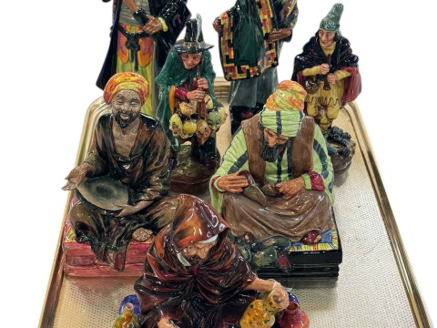 Seven Royal Doulton figures including Blue Beard, Carpet Seller, The Mask...