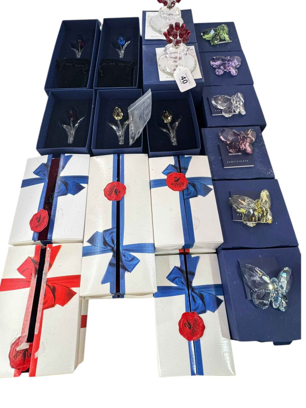 Collection of boxed Swarovski butterflies, flowers, petals, and two hearts.