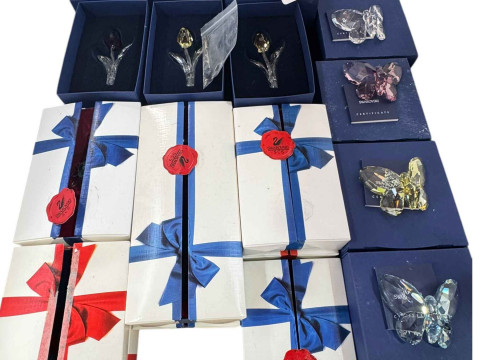 Collection of boxed Swarovski butterflies, flowers, petals, and two hearts.