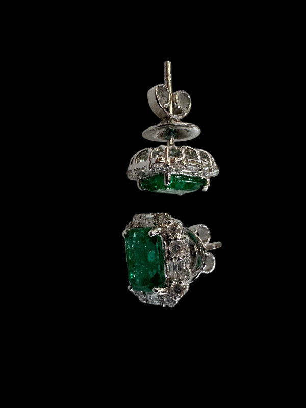 Pair of 18 carat emerald and diamond cluster earrings, rectangular emerald surrounded by baguette and brilliant cut diamonds.
