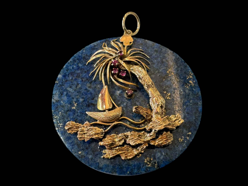 Gold mounted and gem set lapis lazuli pendant with palm tree shore scene, (14ct?) 4.5cm diameter.