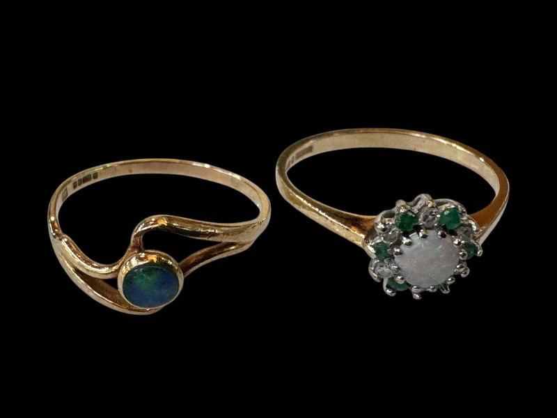 Two 9 carat gold opal set rings, one with emeralds.