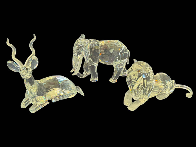 Three Swarovski crystal African animals including elephant, lion and kudu, all boxed.
