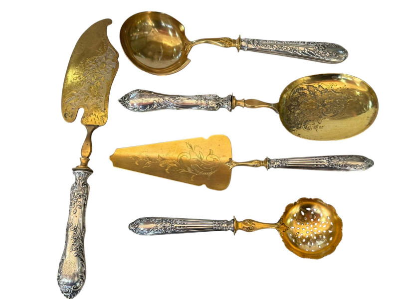 Five French silver handled servers, a pair with chased decoration and three with matching handles.