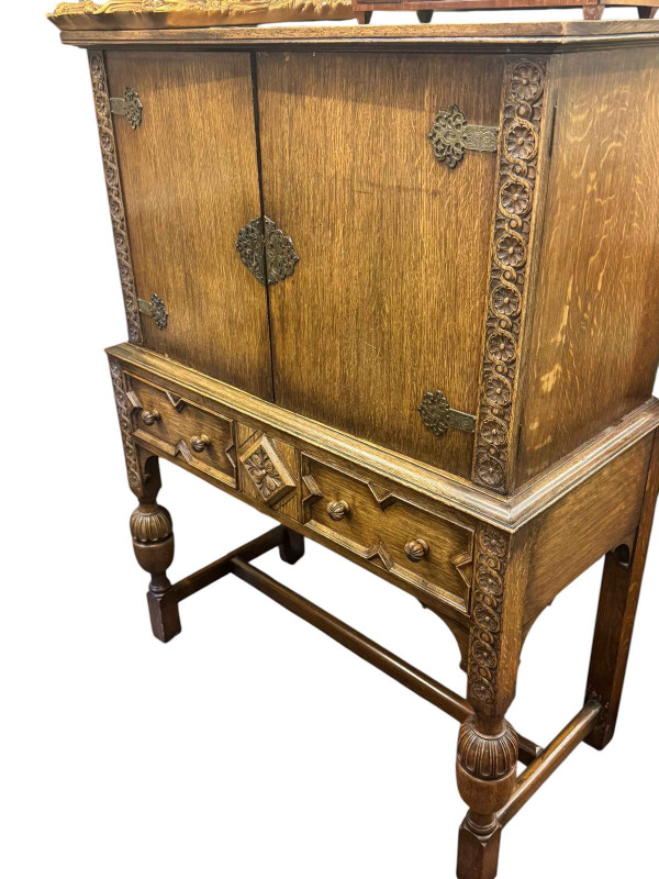 1930's oak two door cabinet on two drawer stand, draw leaf dining table and five dining chairs including one carver (7).