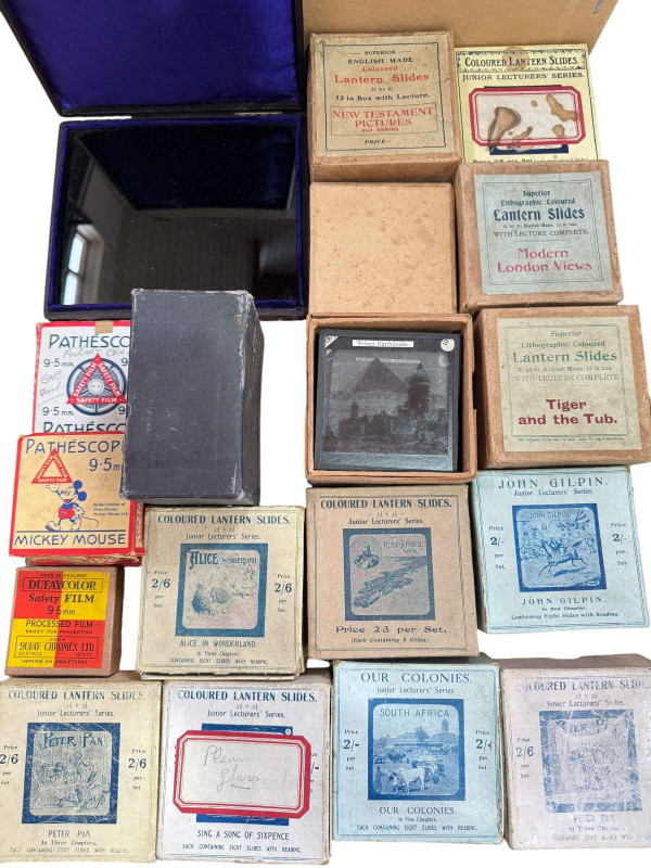 Pathescope Home Cinema with tape reels and a collection of boxed lantern slides.