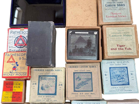 Pathescope Home Cinema with tape reels and a collection of boxed lantern slides. thumbnail