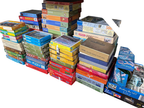 Large collection of jigsaw puzzles including various train illustrations. thumbnail