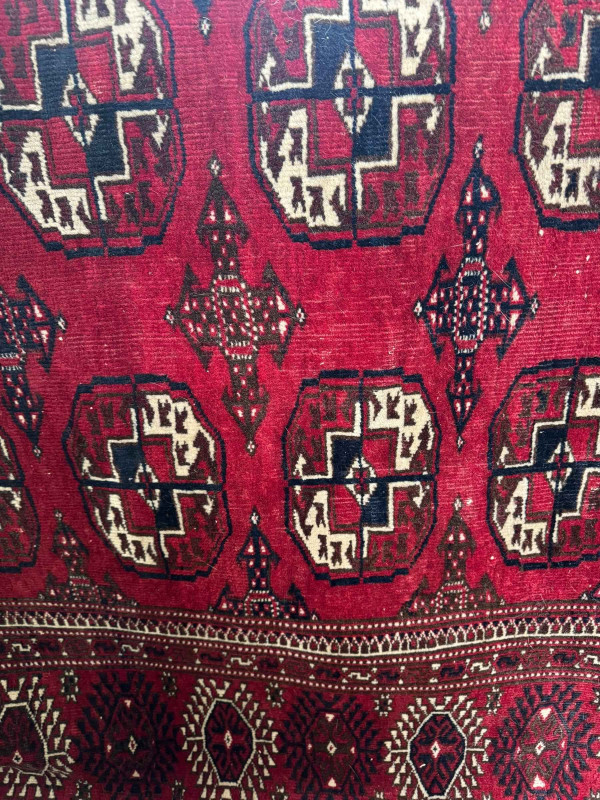 Early 20th Century Tekke Turkoman carpet with repeating boleh pattern and geometric border, 327cm by 112cm.